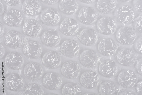 A horizontal, full-frame macro shot of clear plastic bubble wrap, creating a repetitive texture of inflated air pockets