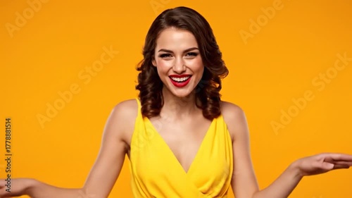 A smiling woman with red lipstick, brown curly hair, and a yellow dress against a yellow backdrop