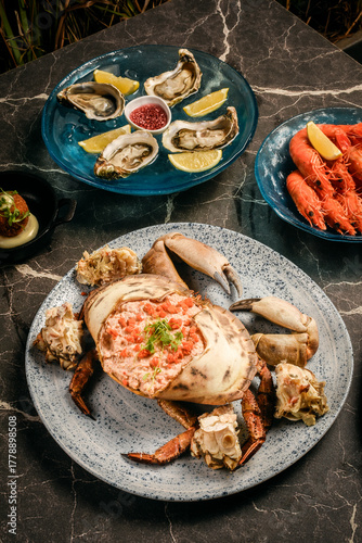 Sapateira Recheada traditional Portuguese stuffed crab meal with mixed seafood side dishes on gourmet restaurant table in Lisbon Portugal