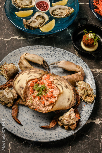 Sapateira Recheada traditional Portuguese stuffed crab meal with mixed seafood side dishes on gourmet restaurant table in Lisbon Portugal