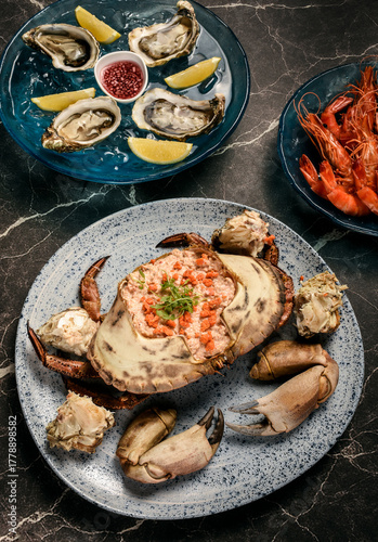 Sapateira Recheada traditional Portuguese stuffed crab meal with mixed seafood side dishes on gourmet restaurant table in Lisbon Portugal