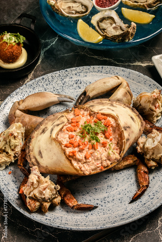 Sapateira Recheada traditional Portuguese stuffed crab meal with mixed seafood side dishes on gourmet restaurant table in Lisbon Portugal