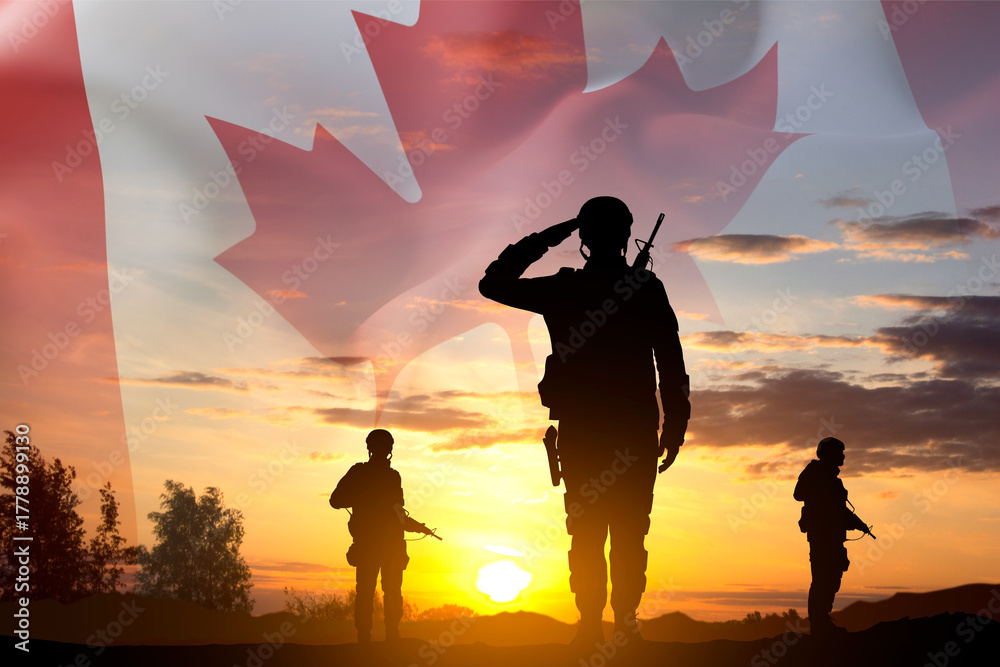 Fototapeta premium Silhouettes of a soldiers with Canada flag against the sunset. Armed Forces of Canada