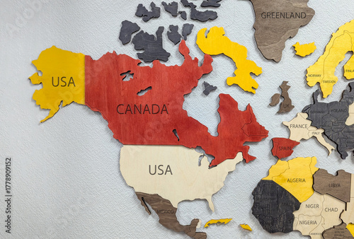 wooden map of North America showing the USA and Canada, Mexico in red and yellow colors. The map features detailed outlines of the countries