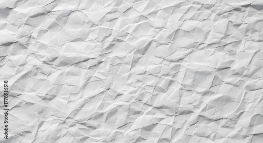 Obraz premium A close-up of a crumpled white paper sheet, showing the intricate folds, shadows, and texture.