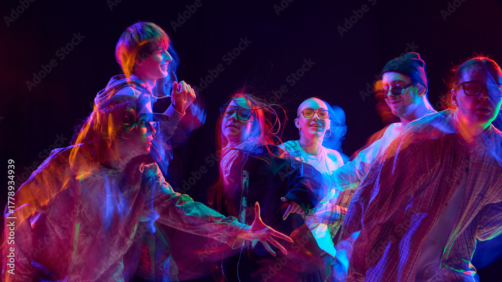 Obraz premium Street dance group illuminated by vibrant motion blur light. Concept of creative performance, modern youth advertising visuals symbolizing teamwork, flow, and vibrant artistic style.