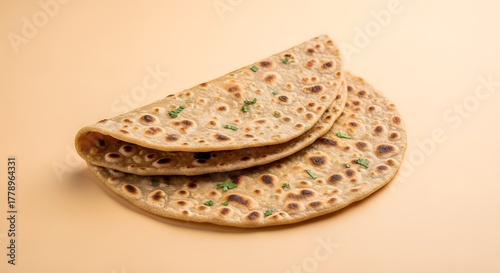 Delicious Homemade Paratha with Fresh Coriander Sprinkles on Beige Background