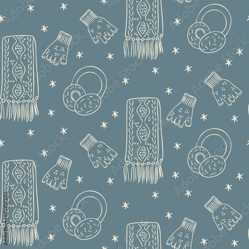 Seamless winter pattern with scarves, mittens and earmuffs in hand drawn outline style on blue background. Concept of cozy season, warmth and cold weather accessories