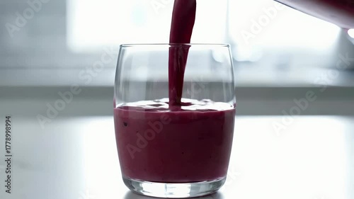 Pouring a Fresh Berry Smoothie into a Glass from a Blender
