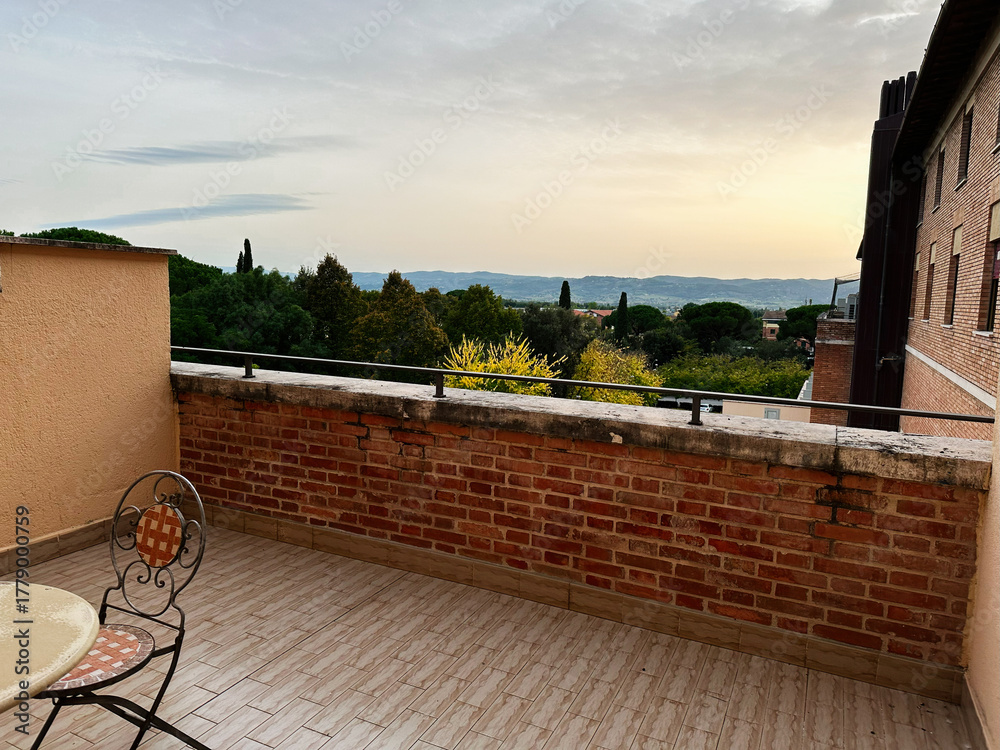 Obraz premium Terrace overlook in Assisi Italy with brick railing and sunset over hills and trees