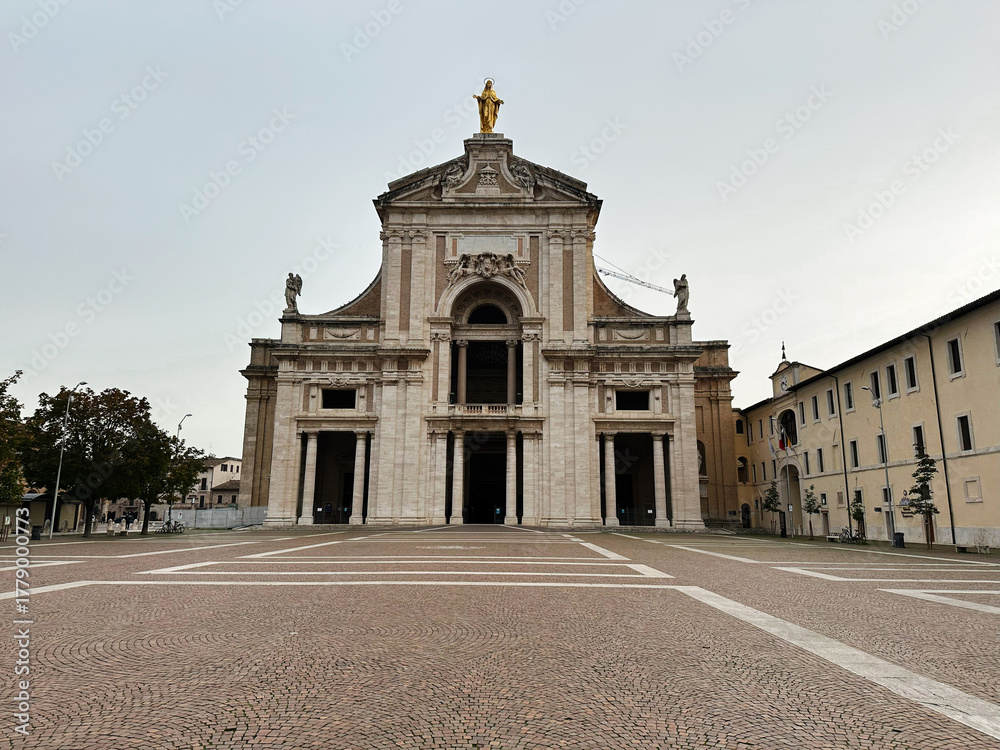 Fototapeta premium Assisi Italy grand church Basilica of Saint Mary of the Angels facade with arches and a golden statue atop historic basilica