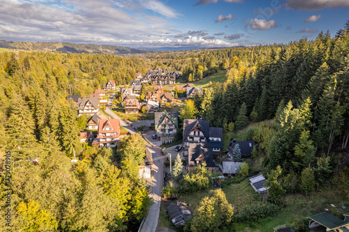Fototapeta Naklejka Na Ścianę i Meble -  Aerial view of mountain village in Poland surrounded by forests, sunny autumn day