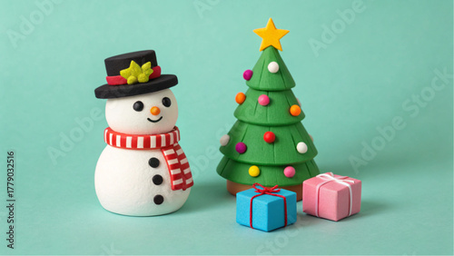 Cute handmade snowman and christmas tree with gifts against a teal background