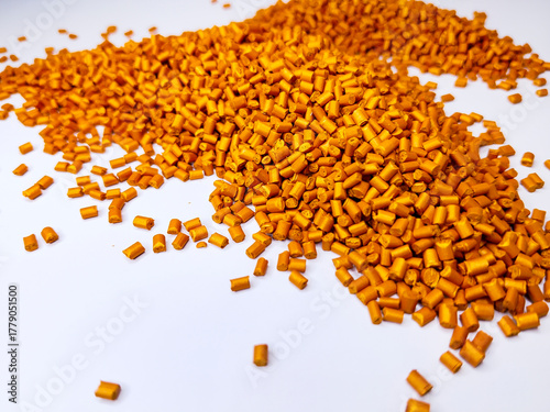 Orange masterbatch granules, cold cutting type, polymer carries color pigment poured into a white background medium, suitable for product catalog design of industrial plastic company profiles