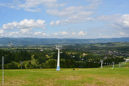 Fototapeta Naklejka Na Ścianę i Meble -  Bialka Tarzanska, Poland. Alpine ski lift or chairlift from Bialka Tarzanska to the station at the top of the mountain Kotelnica. Summer in Poland, Europe