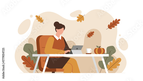 Autumn remote work concept Woman uses tablet at a desk surrounded by fall foliage and pumpkin decoration