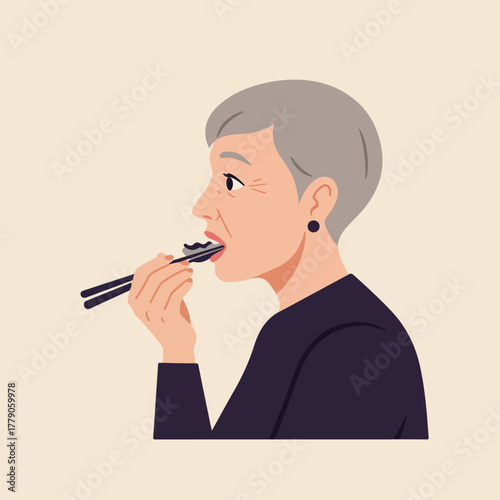 An older woman with gray hair eats food with chopsticks. She wears a dark shirt and a black earring