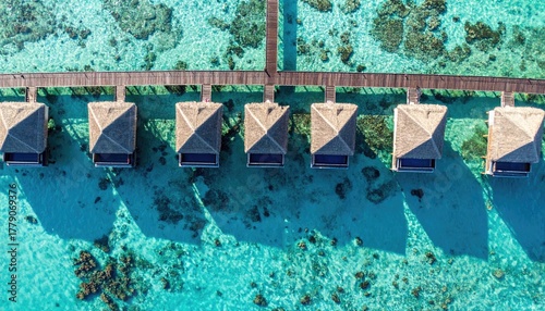 Aerial View Of Overwater Bungalows In Crystal Clear Turquoise Water With Wooden Walkway On Sunny Day