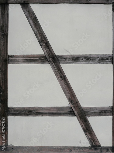 Half-timbered wall with diagonal brace and weathered wooden beams historic architecture