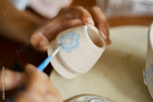 Close up hand of woman painting her pottery ceramic