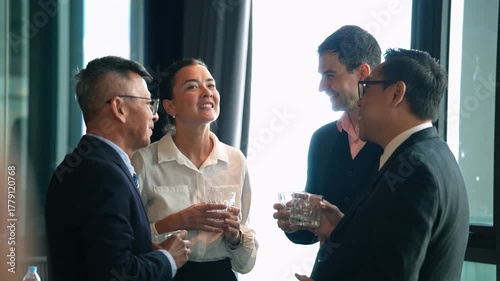 Diverse group of business professionals networking and engaging in a casual conversation during a corporate event or office New year party. Social gathering, compnay meeting