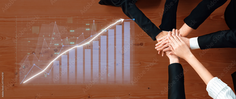 Fototapeta premium Business professionals join hands over a graph chart symbolizing collaboration, strategy, and partnership aimed at achieving growth and success in the office environment. Axiom