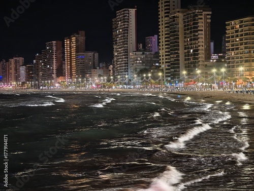 Bilde på lerret restless ocean waves crash by city skyline, neonlit high rises create vibrant wa