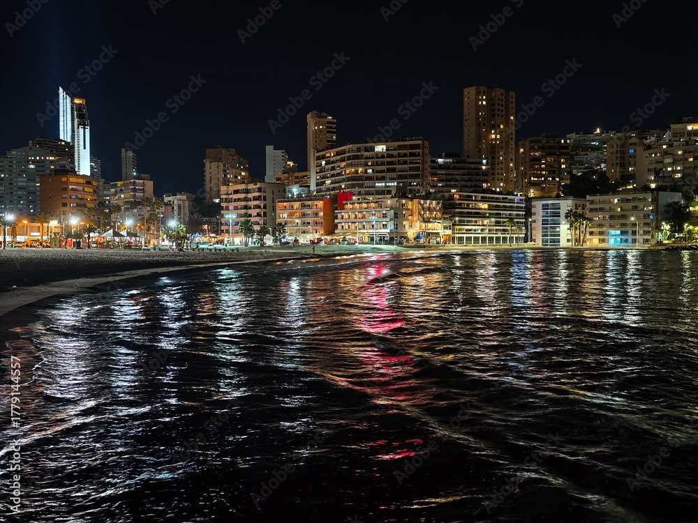 Fototapeta premium vibrant reflections on moving water, bright neon colors flicker across turbulent harbor waters