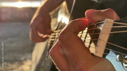 Man plays guitar outdoors. Summer evening