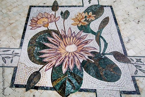 The sidewalk is made of blue, yellow and white mosaics in the form of a lily flower.  Background structure design.