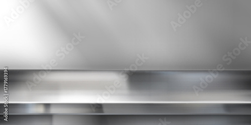 Stainless steel kitchen counter with wall background - metallic silver table top surface in modern cooking space. Industrial metal workspace with smooth polished texture and reflective finish.