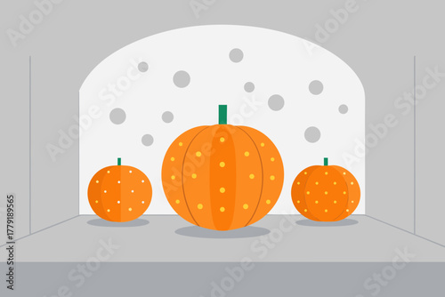 Three stylized orange pumpkins with yellow polka dots displayed in an arched niche with gray walls and a white background featuring scattered gray circles