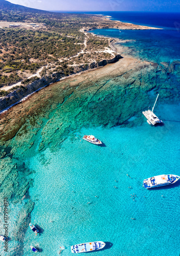 Aerial view of tourists swimming and enjoying the turquoise waters of Chrysochou bay in the blue lagoon, Akamas peninsula, Cyprus