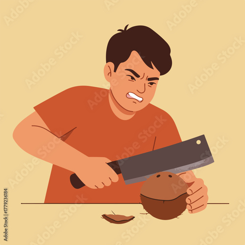 A man struggles to chop a coconut with a cleaver. He is frustrated, looking down at the task. Background is a neutral color
