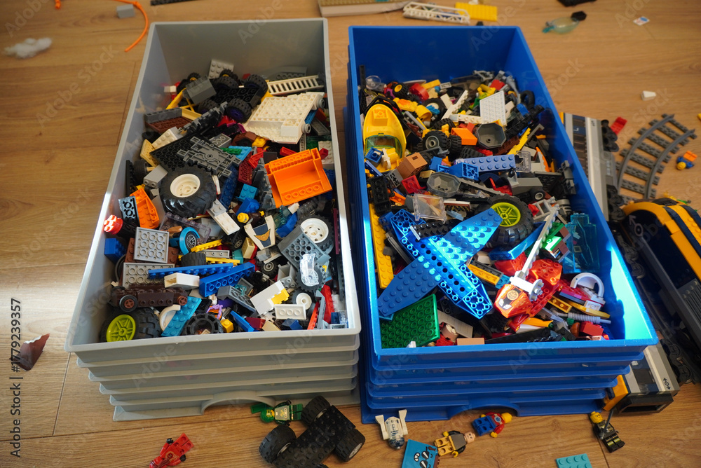 Obraz premium Colorful collection of toy building blocks in storage bins on a wooden floor