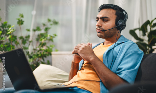 Indian man wearing headset serious thinking sloving problem customer service online technical support