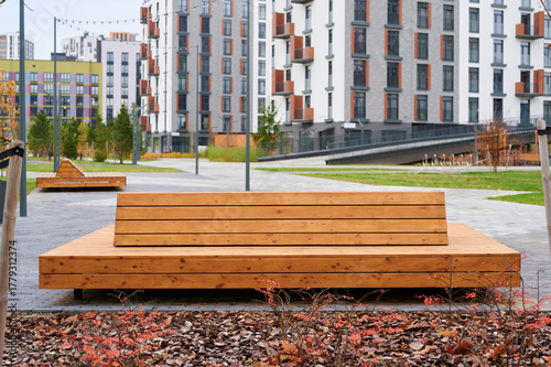 Fotografie contemporary urban park bench in modern residential area, surrounded by newly constructed buildings and landscaped greenery