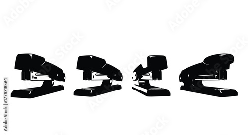 Four black staplers isolated on white background in different positions