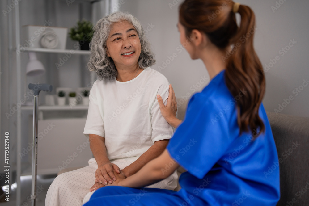 Obraz premium Asian elderly woman receives compassionate nursing care from young caregiver at home providing emotional support for well-being