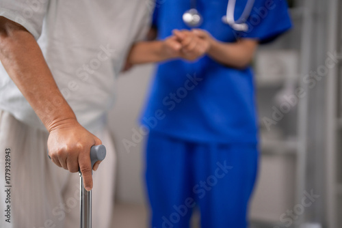 Older adult patient receives walking assistance from nurse rehabilitation support home care medical facility
