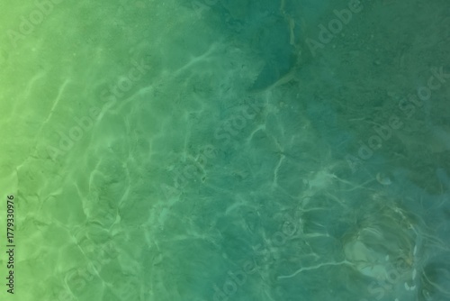 Shallow green ocean water with sunlight ripples, peaceful water texture