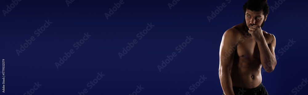 Fototapeta premium Sportive african american man focuses on workout against vibrant blue backdrop