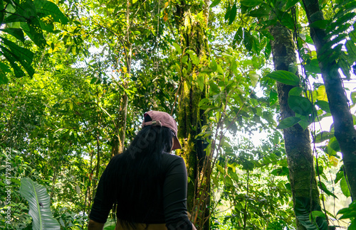 Woman walking in the middle of the lush Amazon rainforest in Latin America.