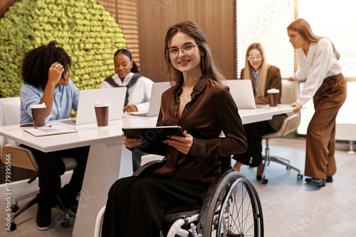 Confident disabled woman using tablet in inclusive modern office