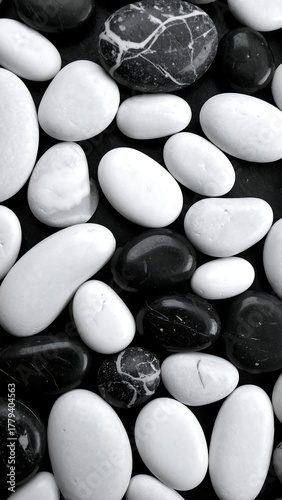 Black and white pebbles arrangement. Smooth stones on black surface