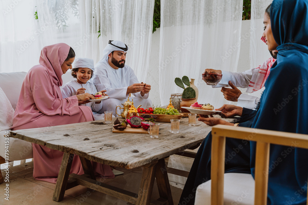 Fototapeta premium Emirati family at home. Muslim family sharing iftar at countryside home.