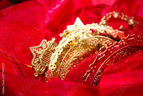 Delicate golden Christmas tree decorations sacked in a soft red fabric