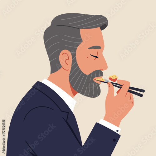 A profile view of a man, wearing a suit, eating food with chopsticks. Background is plain