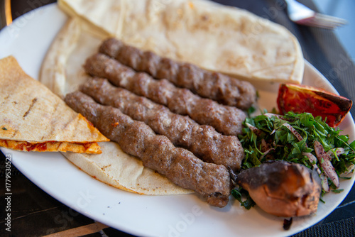 Traditional syrian kebab with pita bread, stewed tomatoes and herbs