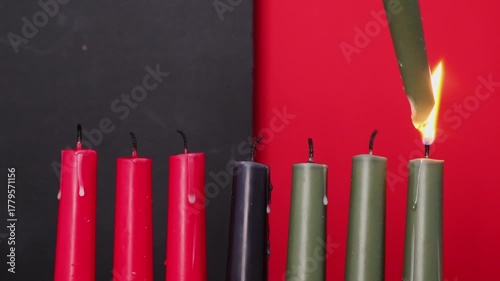 African American Kwanzaa holiday concept with traditional lit candles. Seven candles red, black and green
